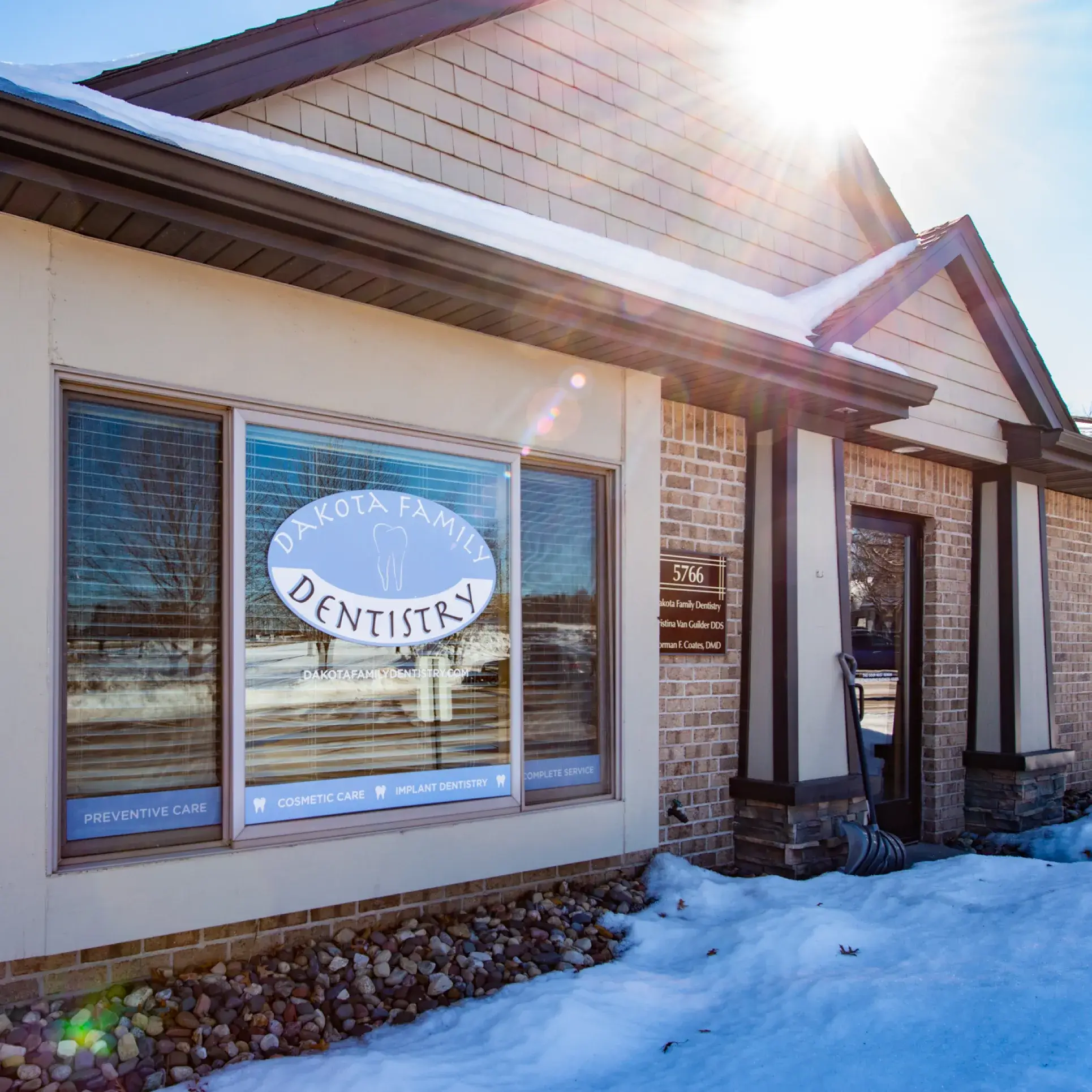 A dental clinic building with a sign reading "Dakota Family Dentistry" on a snowy day.